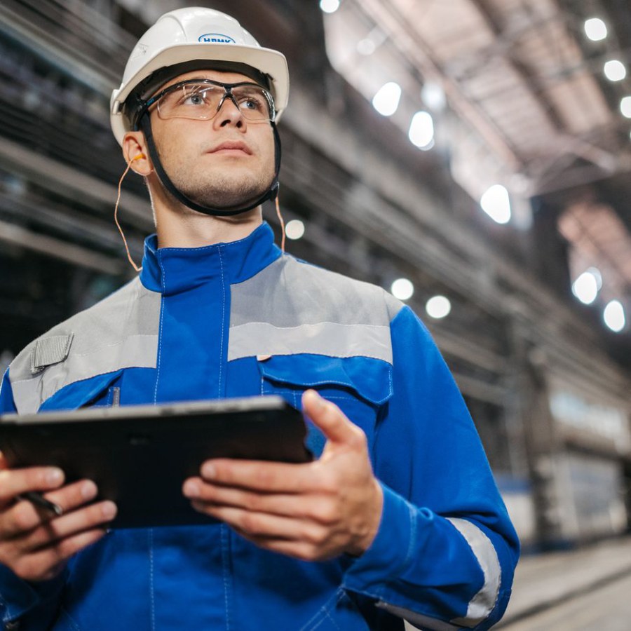 Technicien consultant les données de production sur une tablette dans un atelier