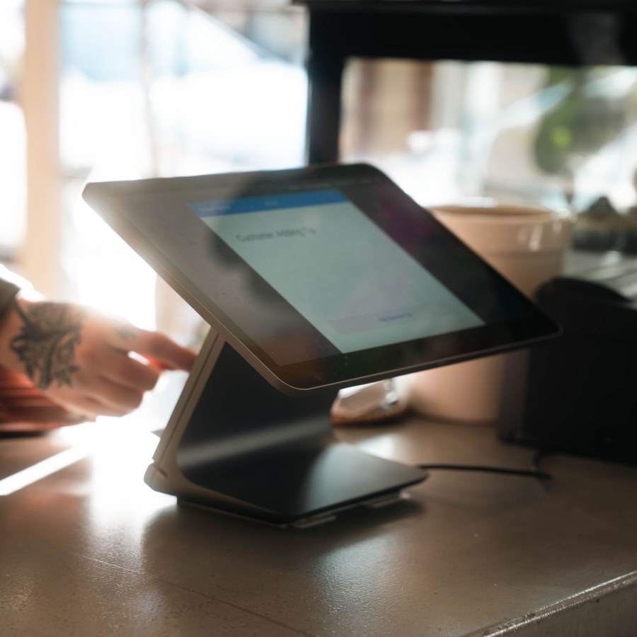 Terminal de point de vente posé sur le comptoir d'un commerce, à la lumière de la vitrine